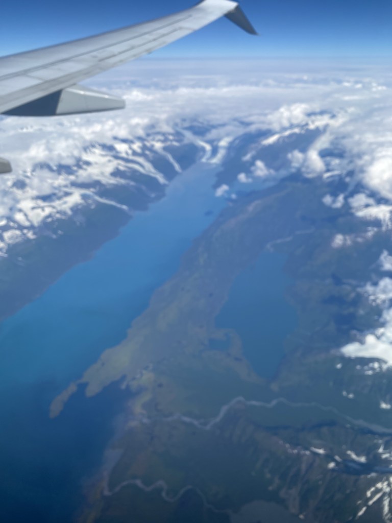 View of snow covered mountians out of airplane window.