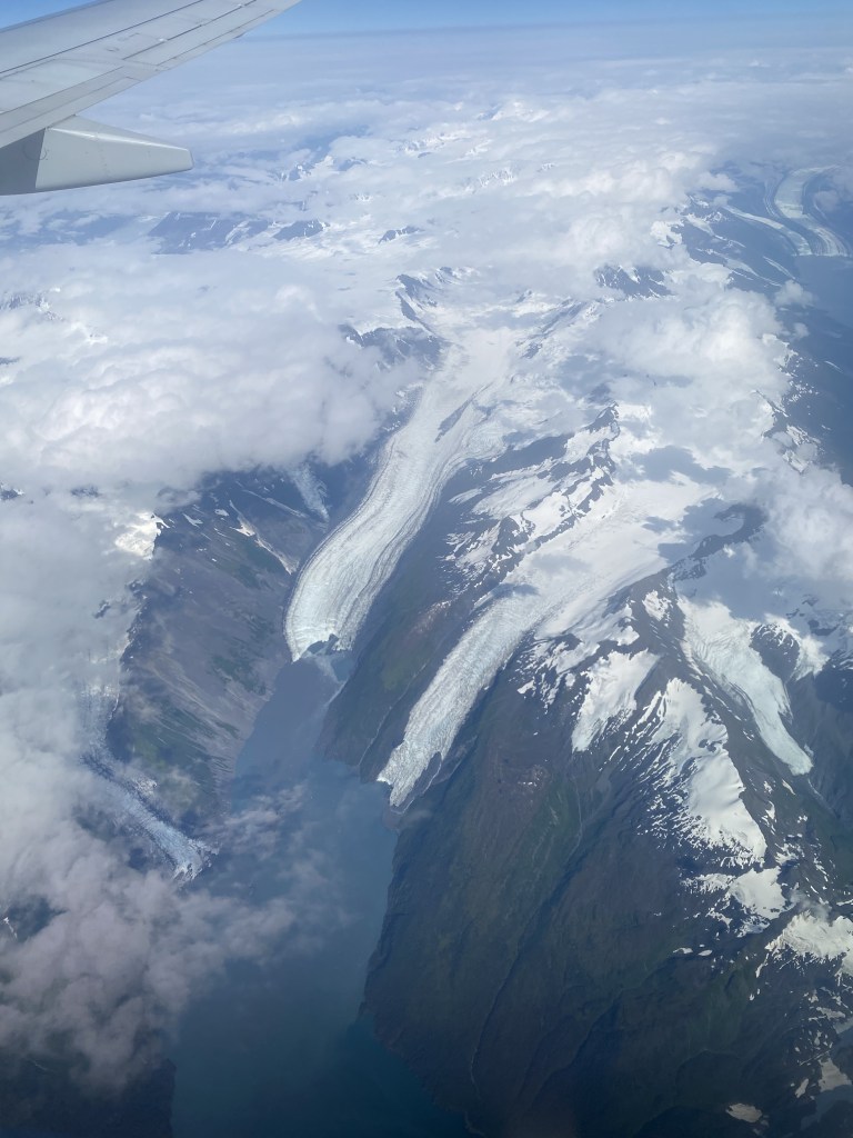 View of snow covered mountians out of airplane window.