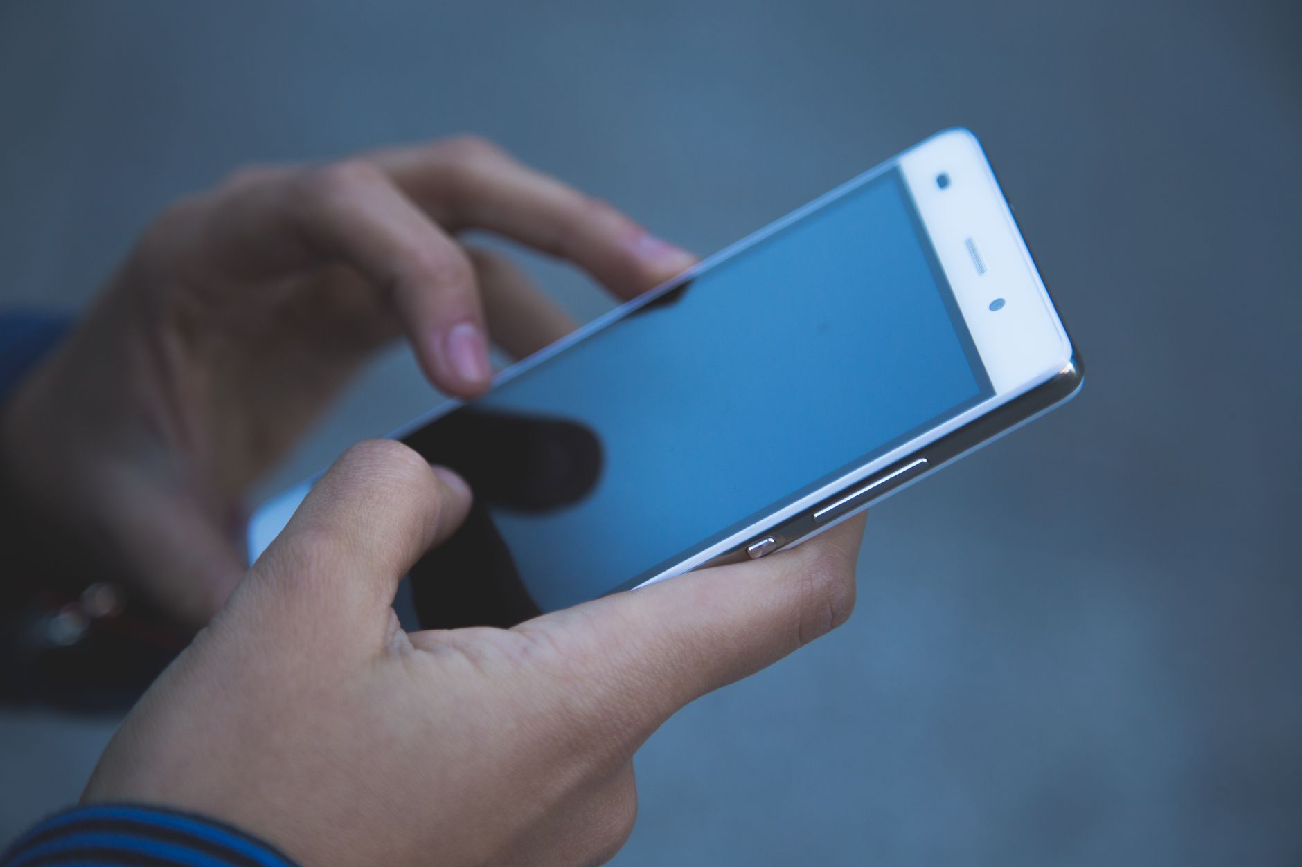 Hands holding cell phone.